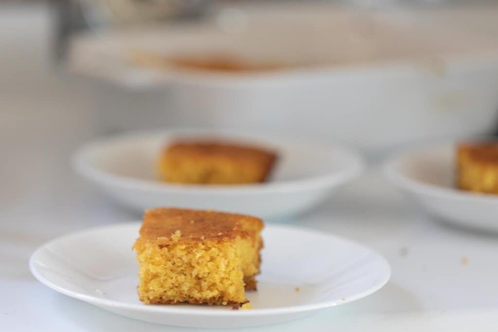 slices of cornbread on white plates on a white countertop