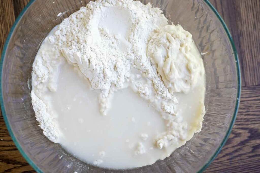 gluten free flour, sourdough starter, water, and salt in a glass bowl