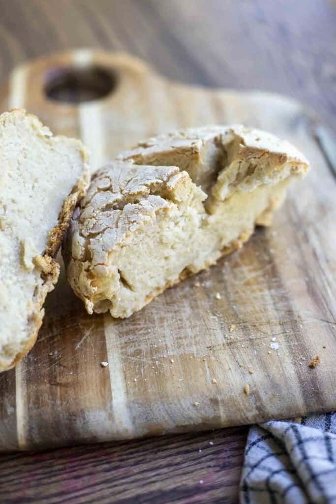 sourdough gluten free bread sliced in half on a wood cutting board