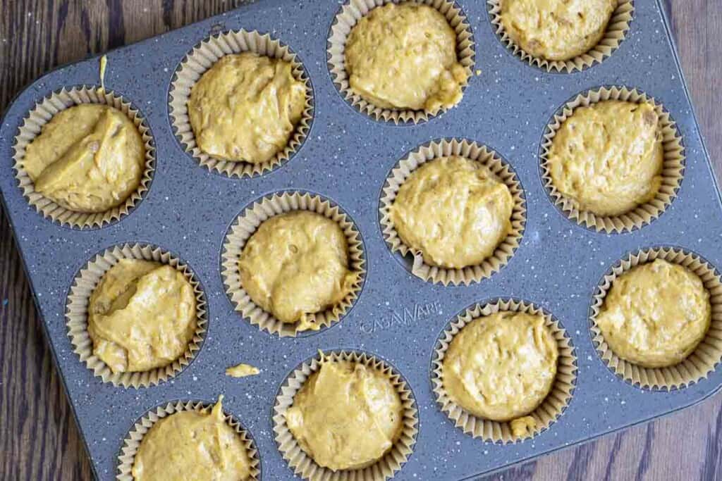 pumpkin muffin batter in a lined muffin tin