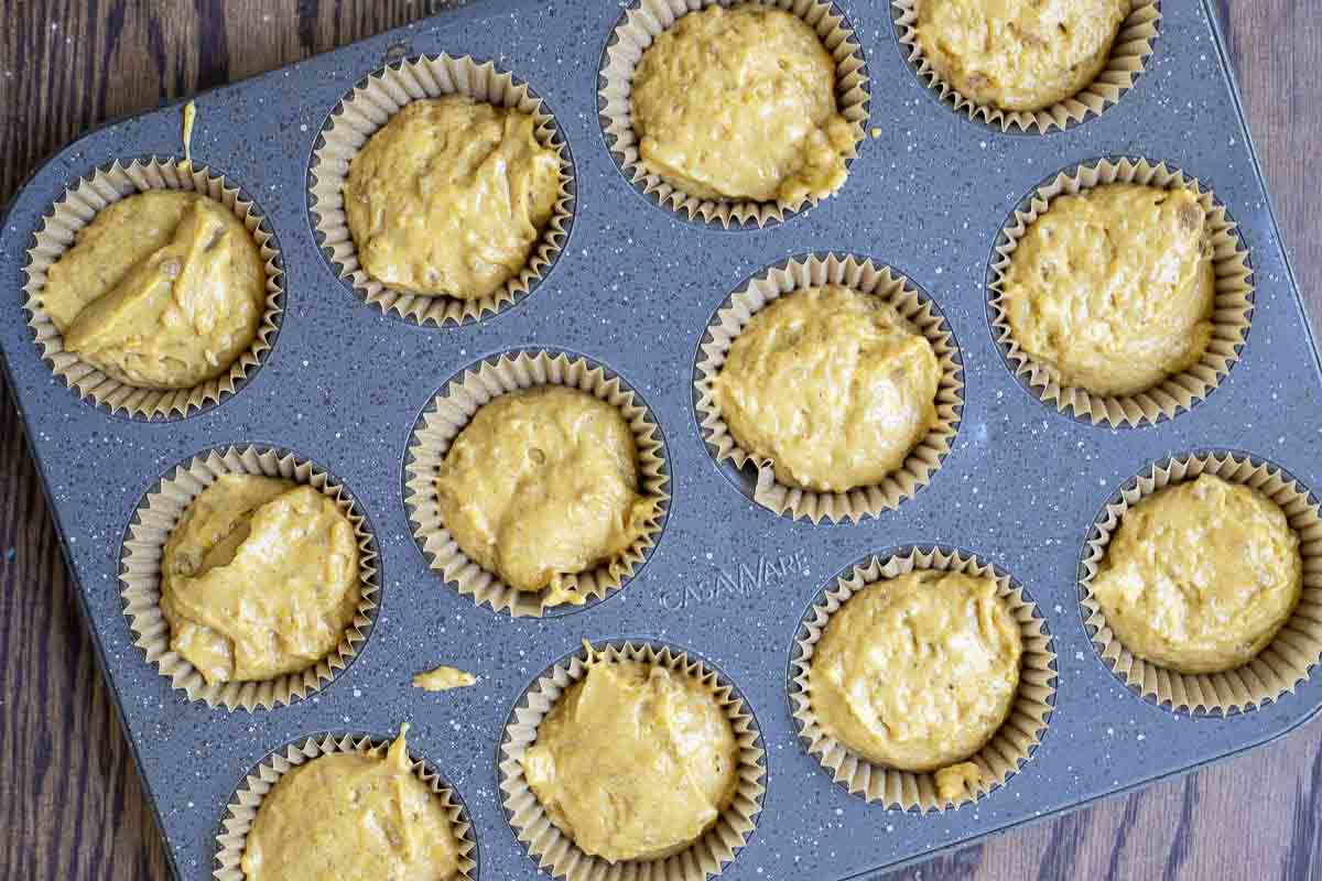 pumpkin muffin batter in a lined muffin tin