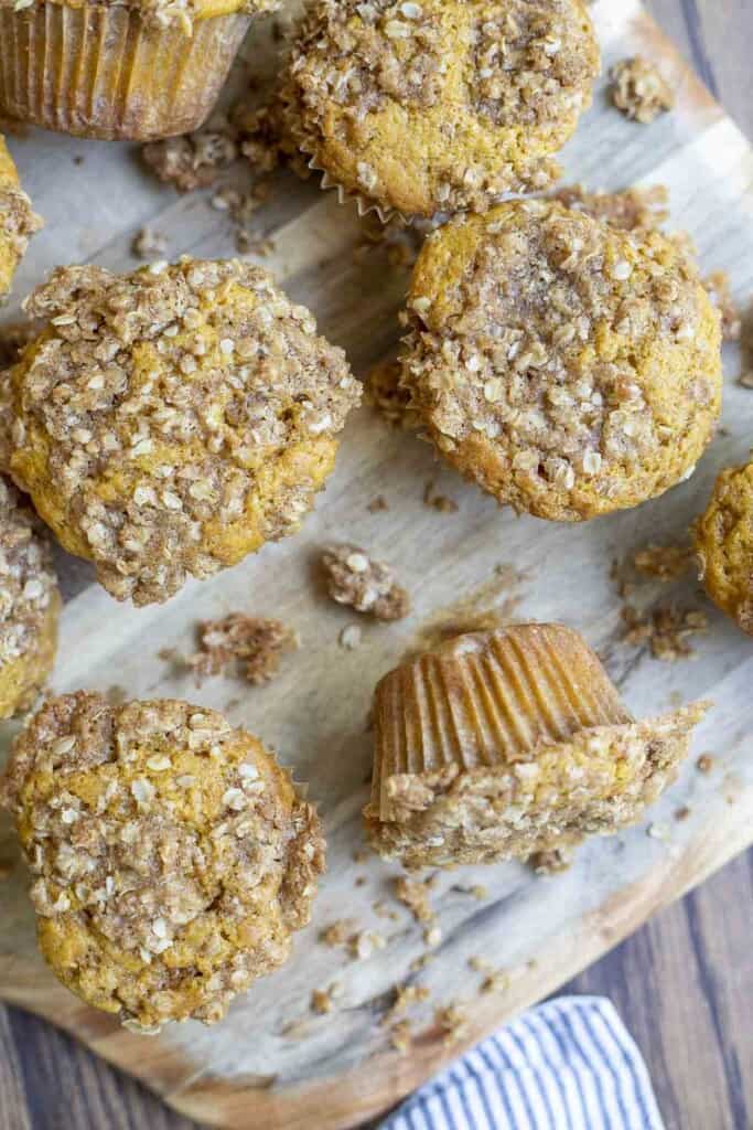 overhead photo of sourdough pumpkin muffins spread out on a wooden cutting board