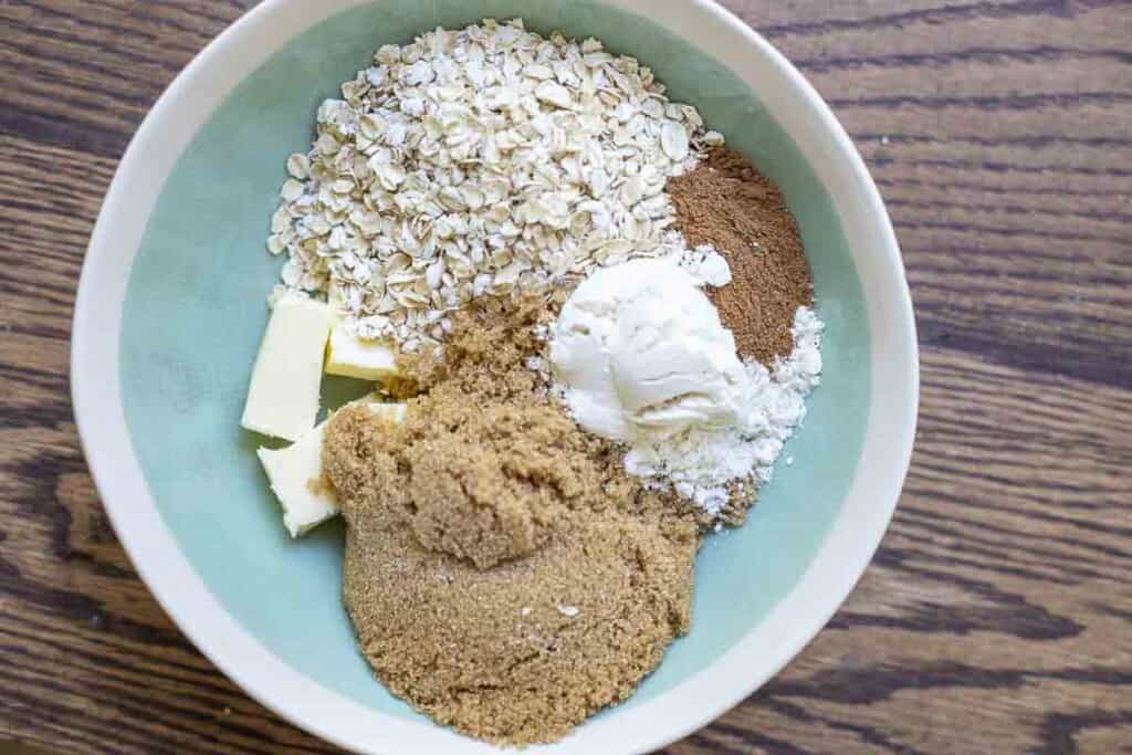 oats, flour, brown sugar, butter, and pumpkin spice in a small turquoise bowl