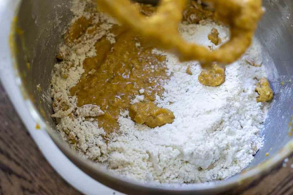 adding flour slowly to a stand mixer bowl