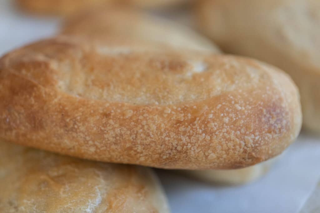 close up of sourdough sandwich rolls with a golden brown crispy outside