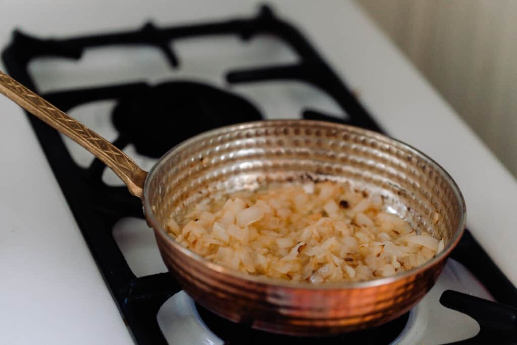 onions and garlic that have been sauteed until sot in a copper pan