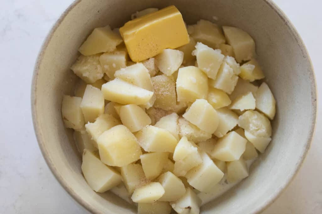 cooked mashed potatoes in a bowl with butter