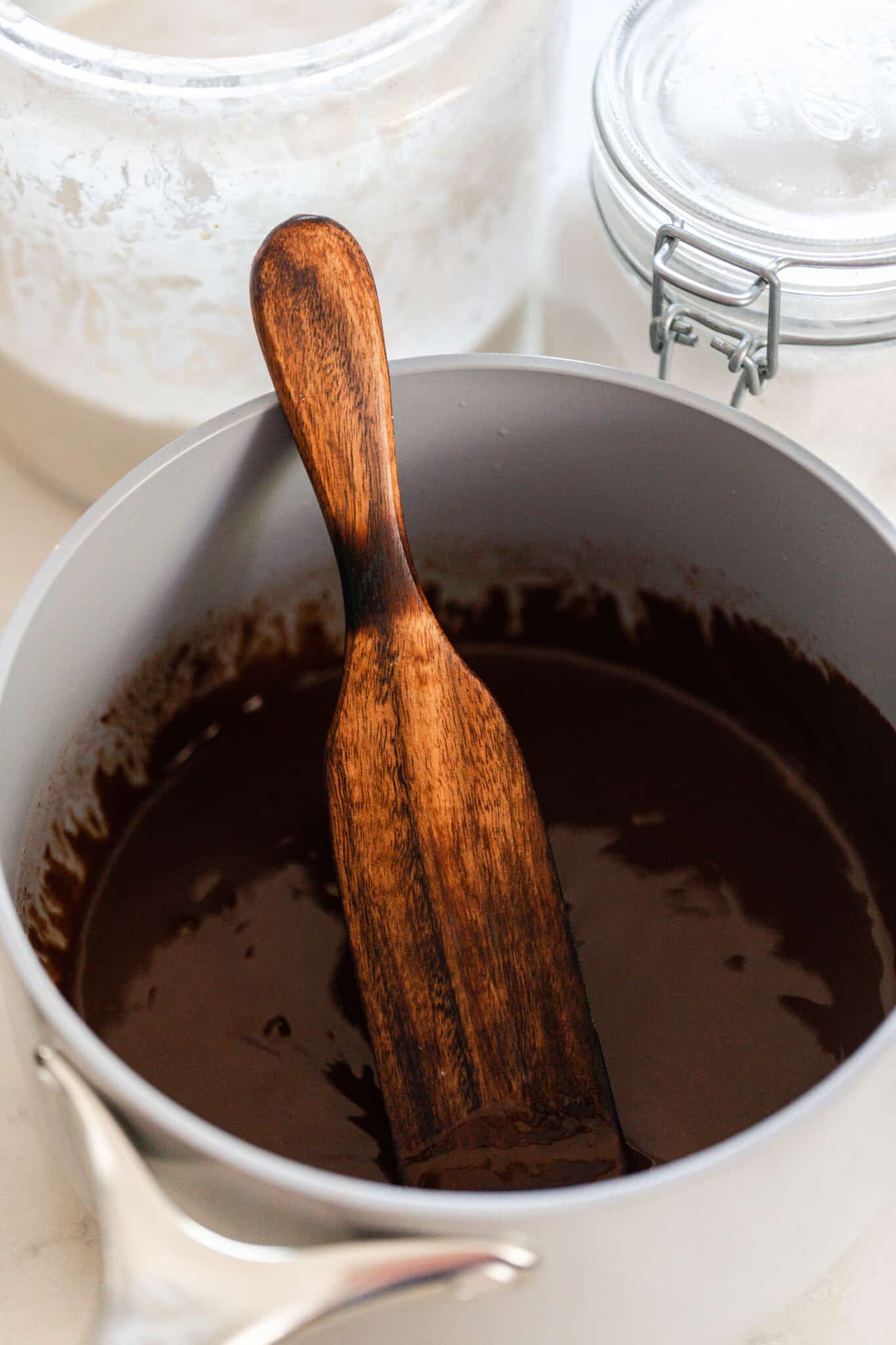 Melted chocolate in a white pot with a wooden spatula