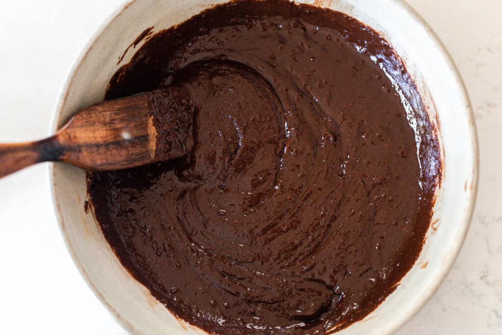 sourdough brownie batter in a large bowl with a wooden spatula