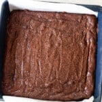 sourdough brownies fresh out of the oven in a parchment lined blue baking dish.