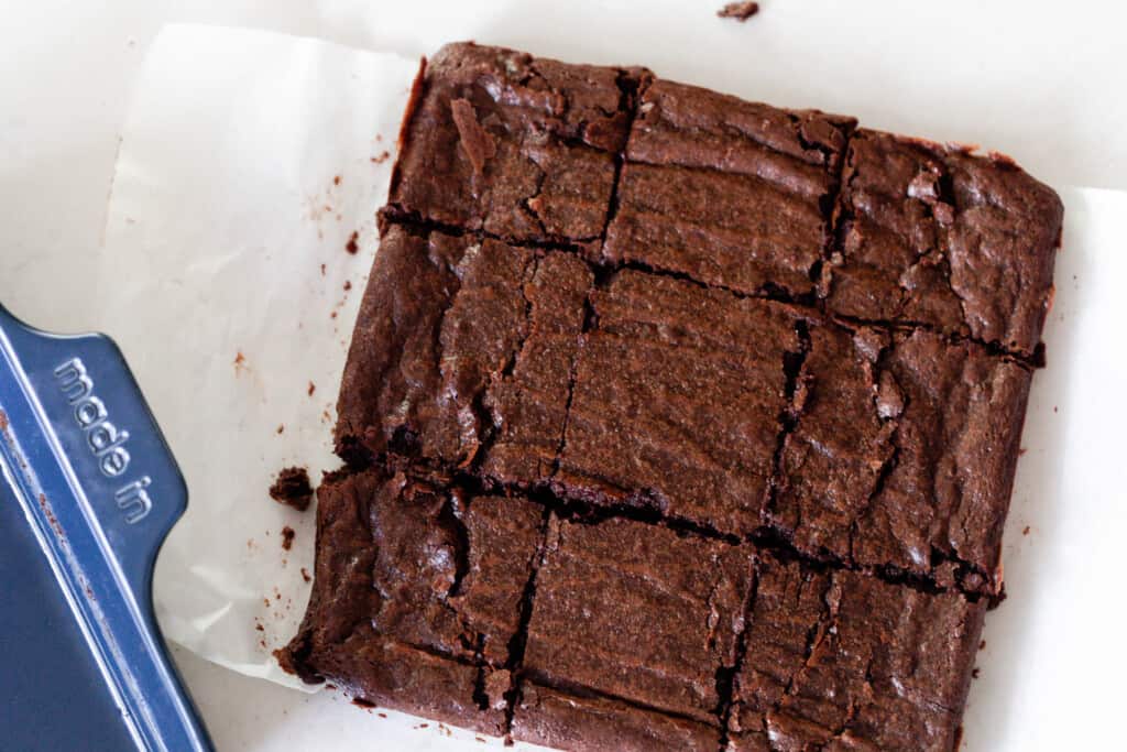 overhead photo of sourdough brownies cut into squares on parchment paper