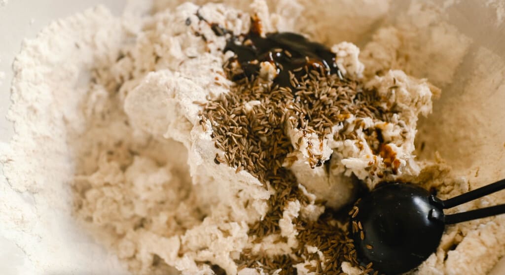 flour, molasses, and caraway seeds in a bowl