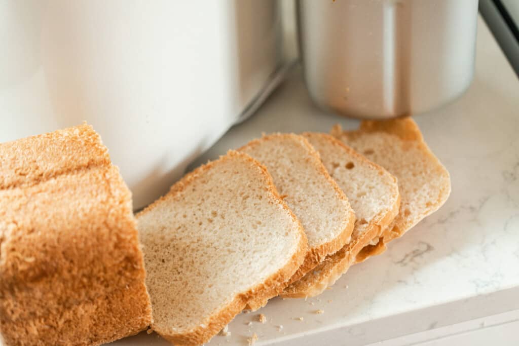 sliced loaf of sourdough sandwich bread on a white quartz countertop