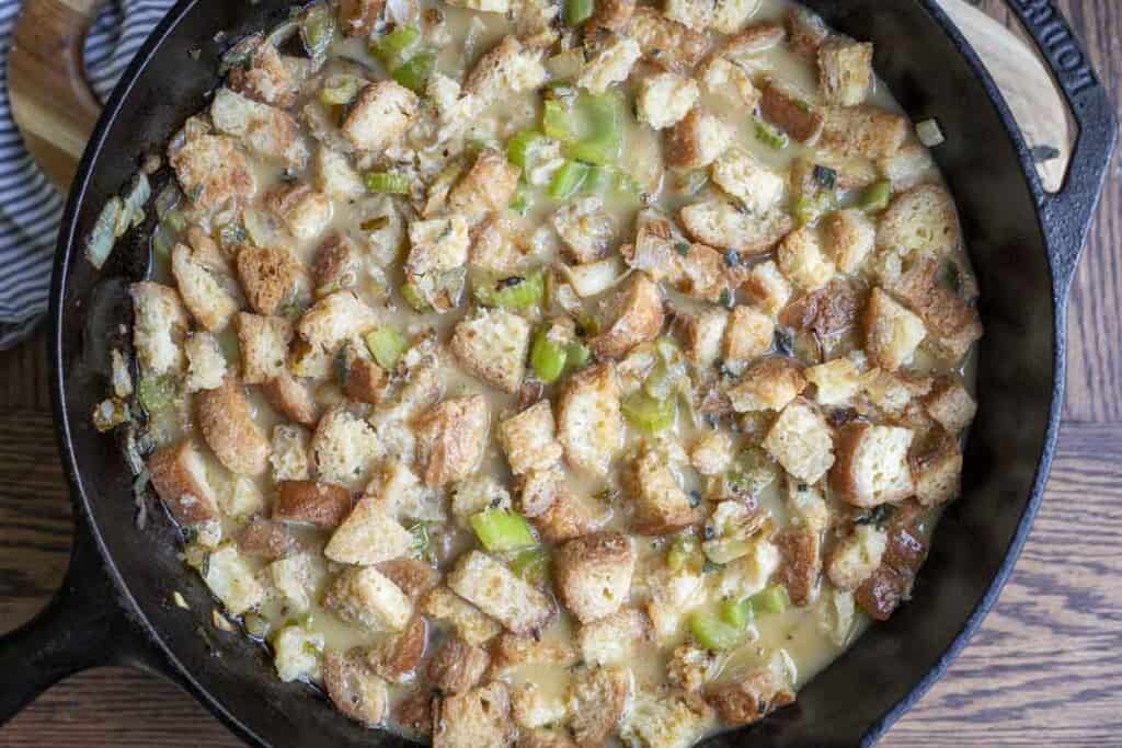 Unbaked gluten free stuffing in a cast iron skillet.