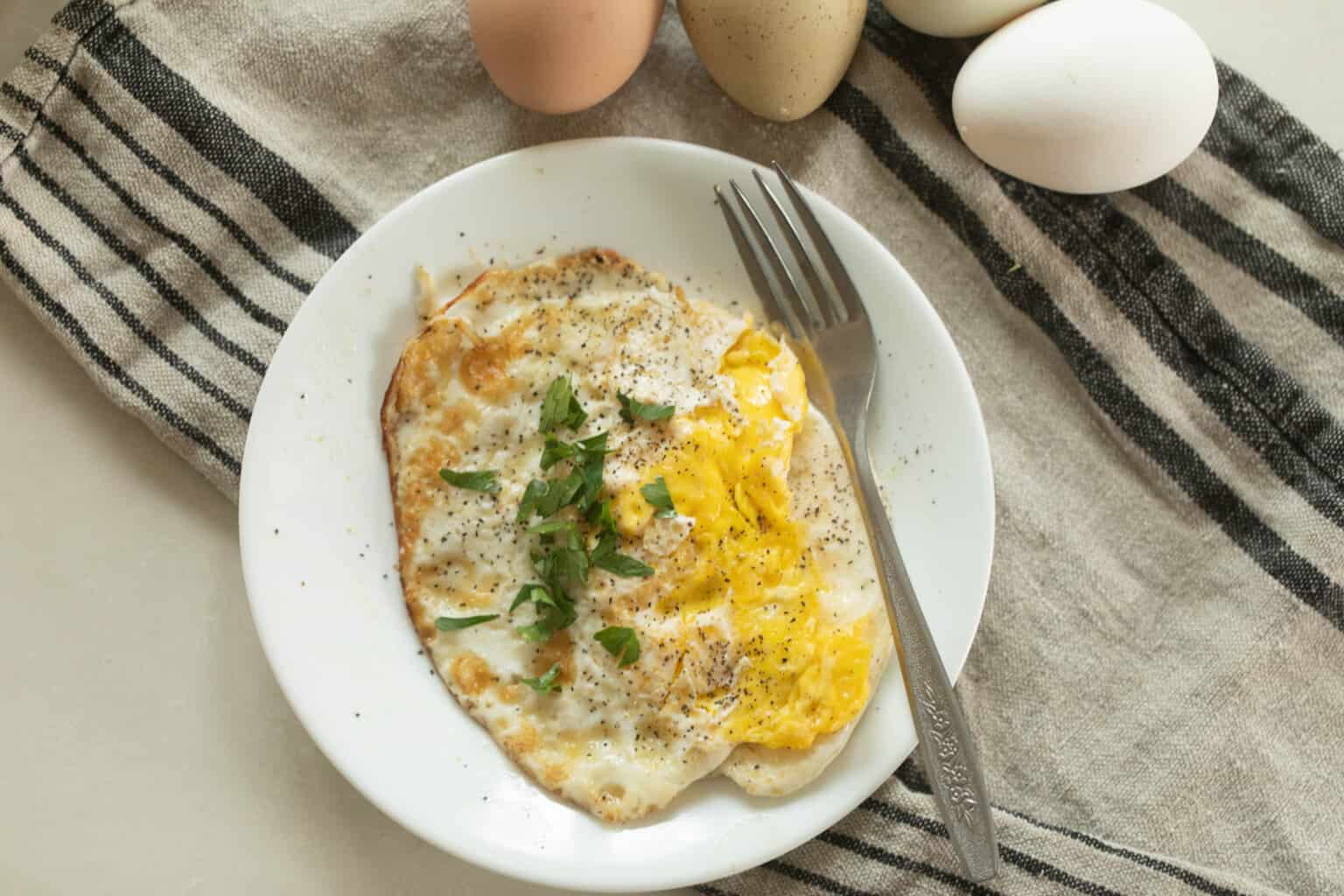 Egg on a plate with a fork.