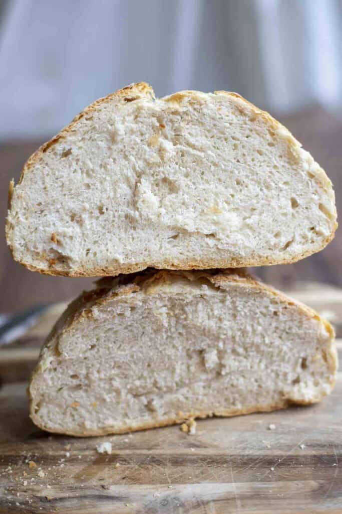 a loaf of bread sliced in half and then stacked on top of each other on a cutting board