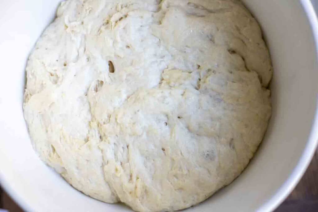 sourdough discard bread dough after fermentation in a white bowl