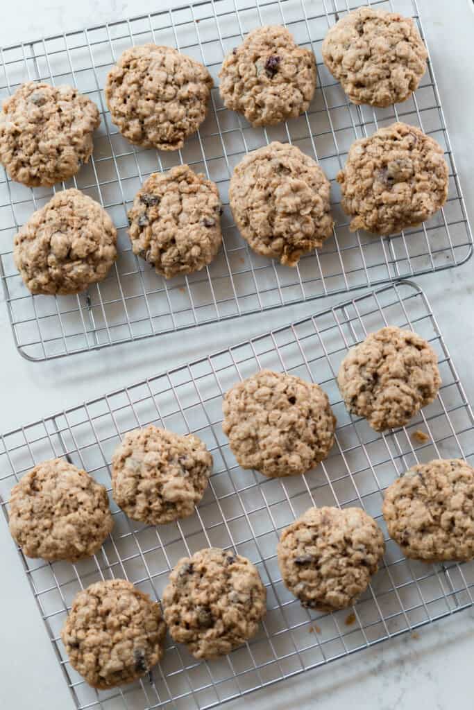 overhead photo os two wire racks full of sourdough oatmeal cookies on a white countertop