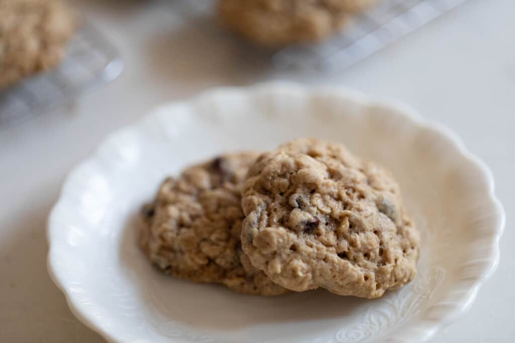 close up picture of two sourdough cookies on a white plate with scallop edge