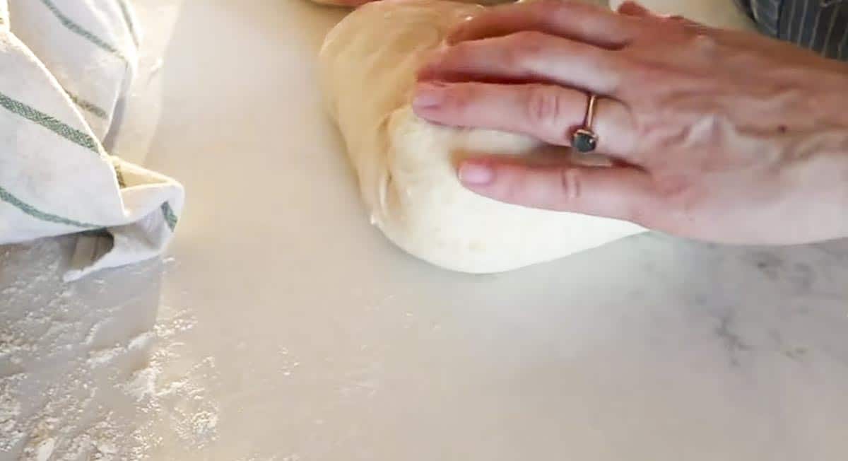shopping a dough ball on a white quartz countertop.
