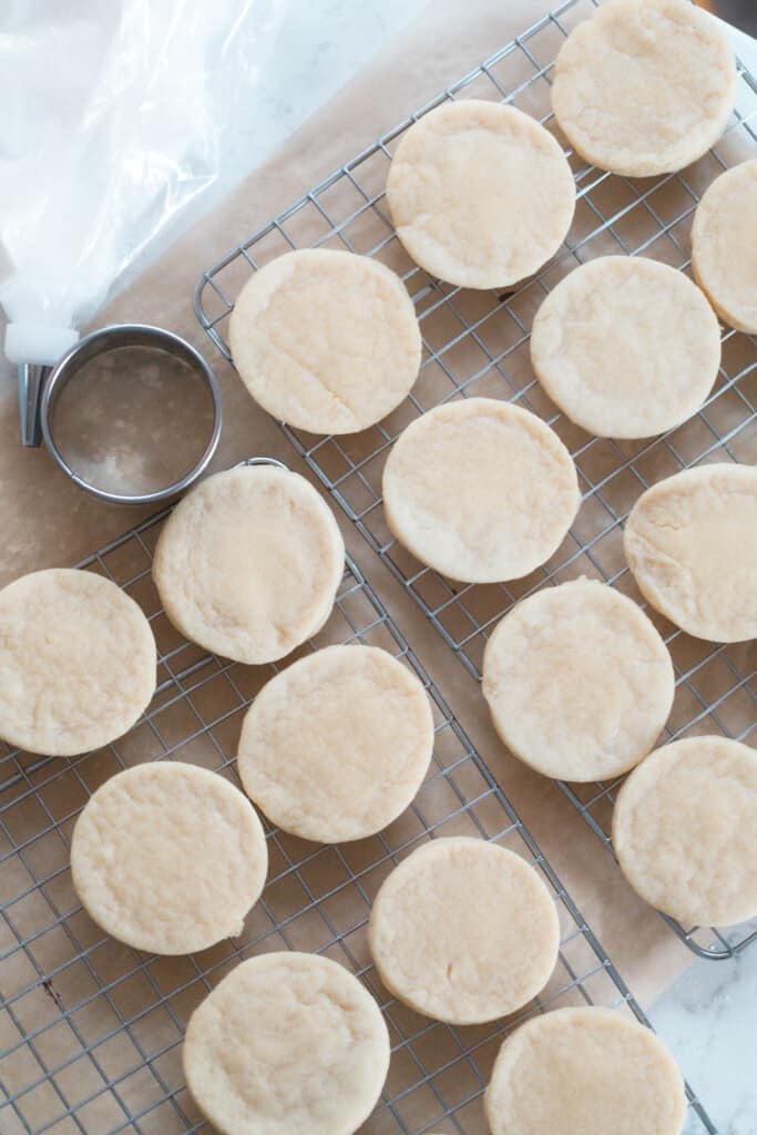 overhead photo of round sourdough cookies on a wire rack over parchment paper
