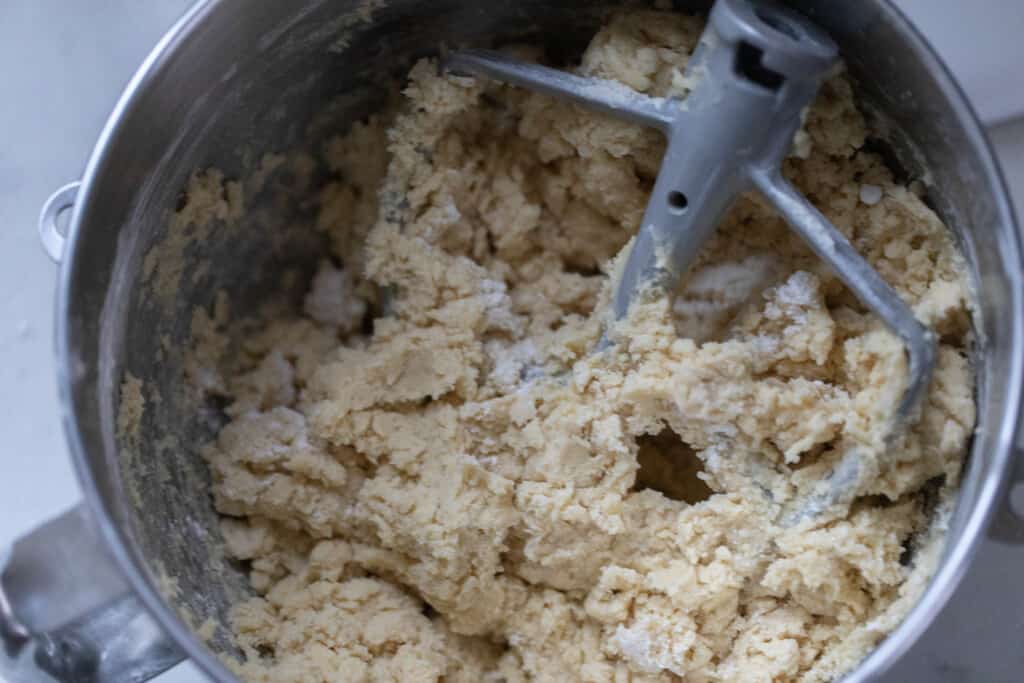 sourdough sugar cookie dough in a stack mixer bowl with a paddle attachment in the dough