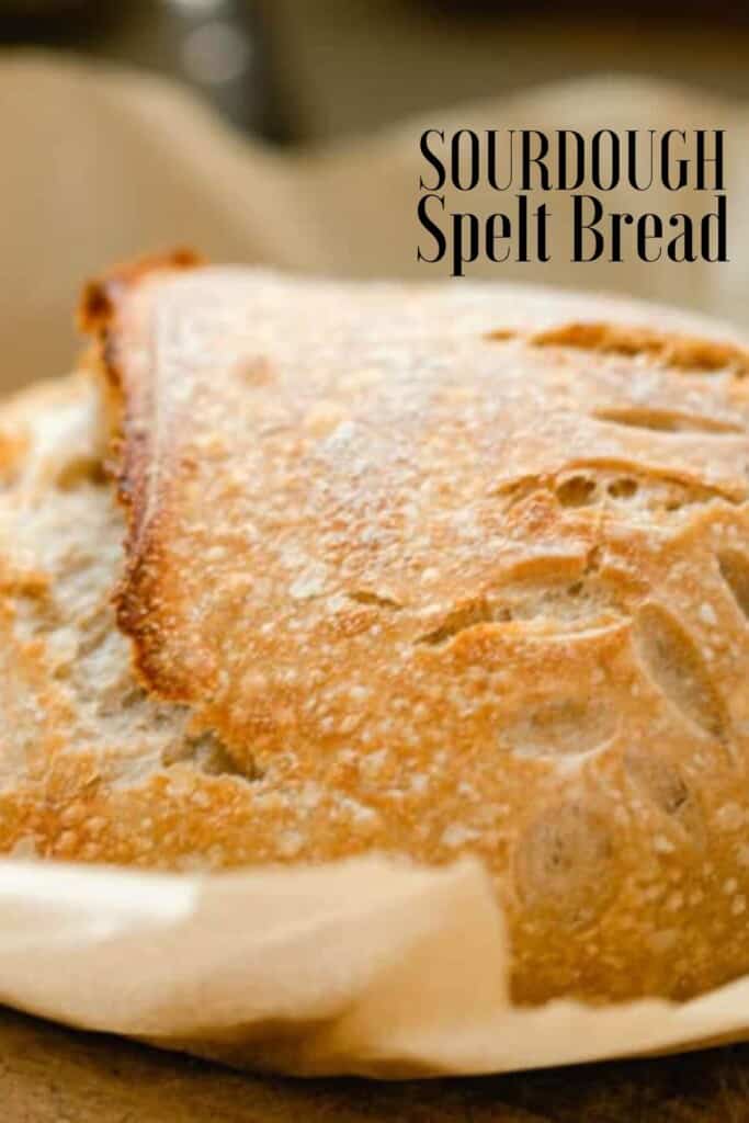 close up of a loaf of sourdough bread with spelt on parchment paper