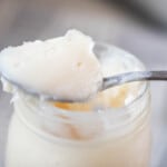 spoonful of lard resting on a mason jar of rendered lard