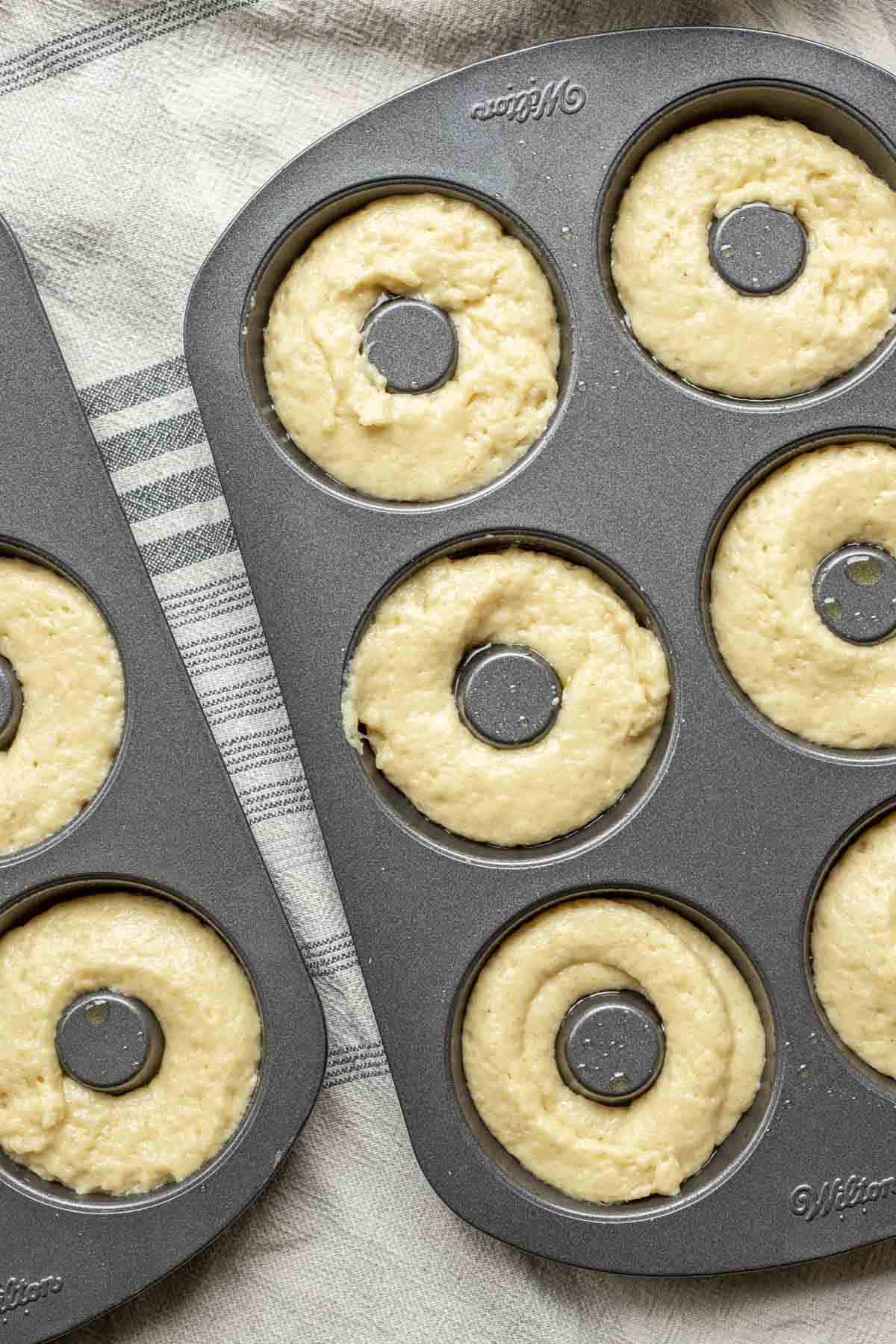 Sourdough donut batter piped into donut pans.