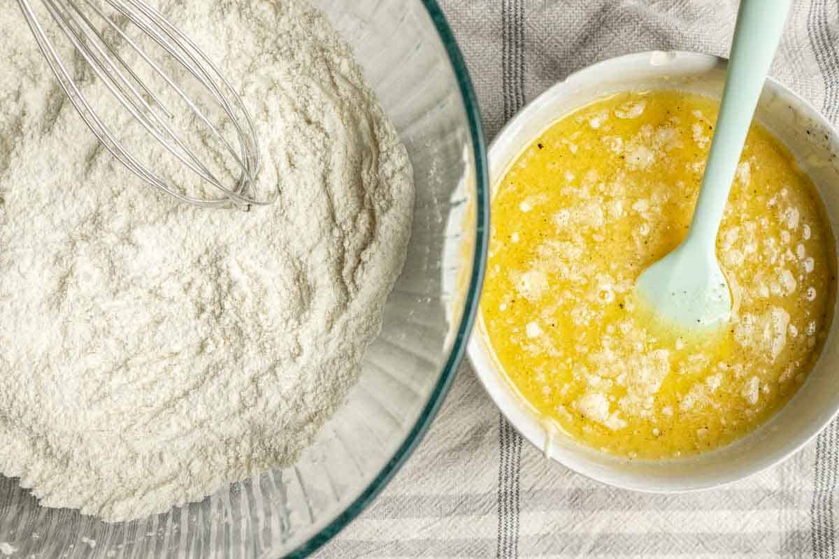 A bowl of flour next to a bowl of melted butter. 