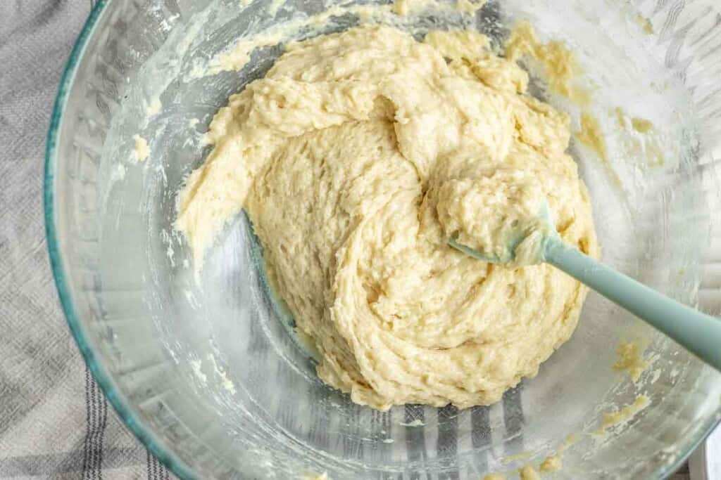 sourdough baked donut batter in a glass bowl with a teal spatula