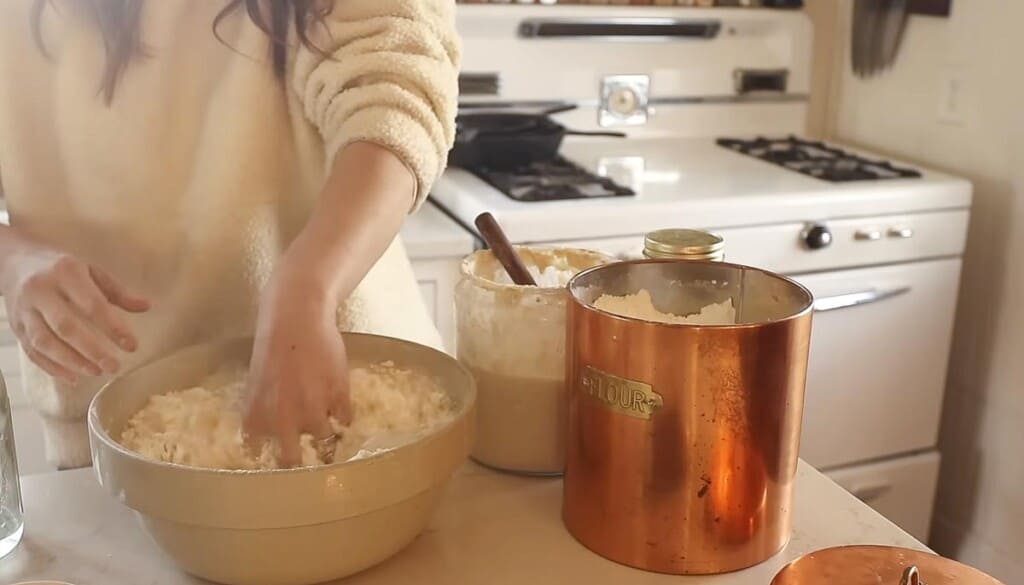 hands mixing dough in a large bowl