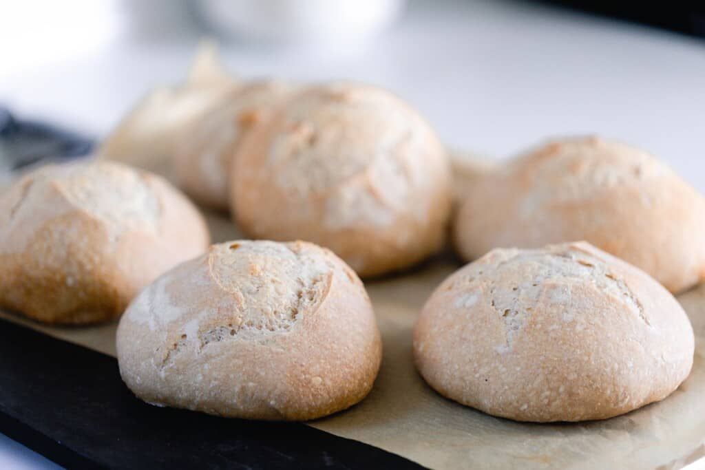 small boules of sourdough bread on a parchment lined board