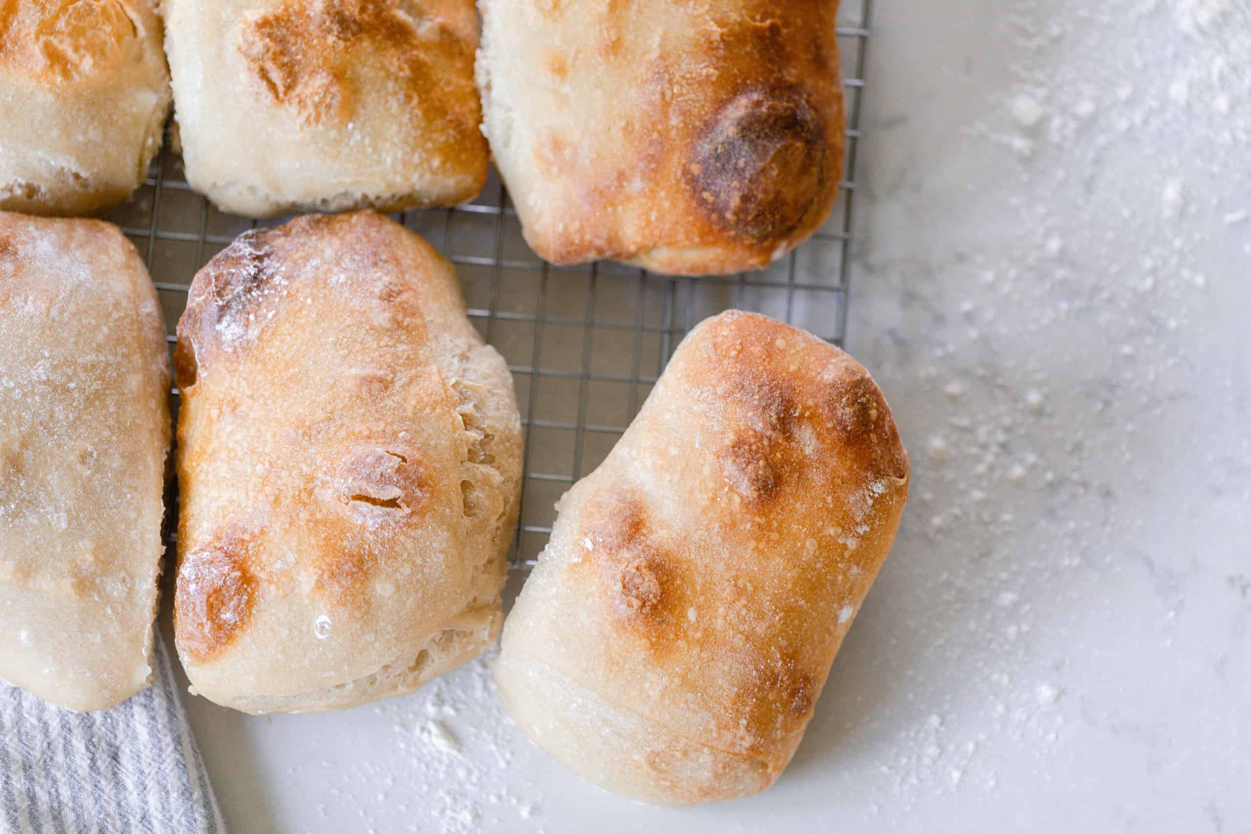 six sourdough ciabatta loaves on a wire rack