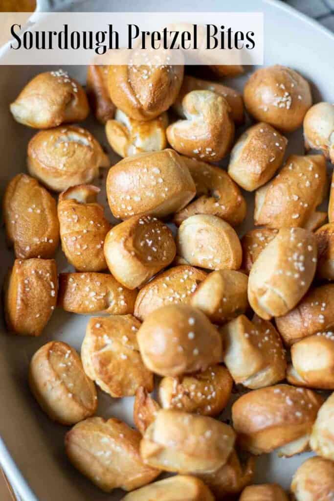 sourdough pretzel bites topped with course salt in an enameled baking dish.