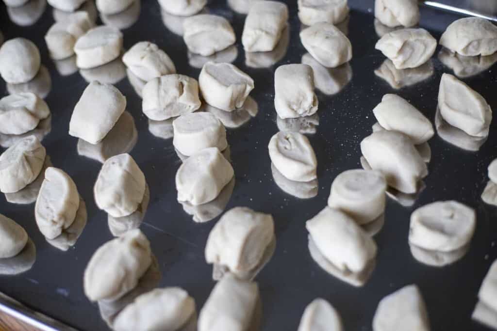 pretzel dough cut into small pieces on a cookie sheet