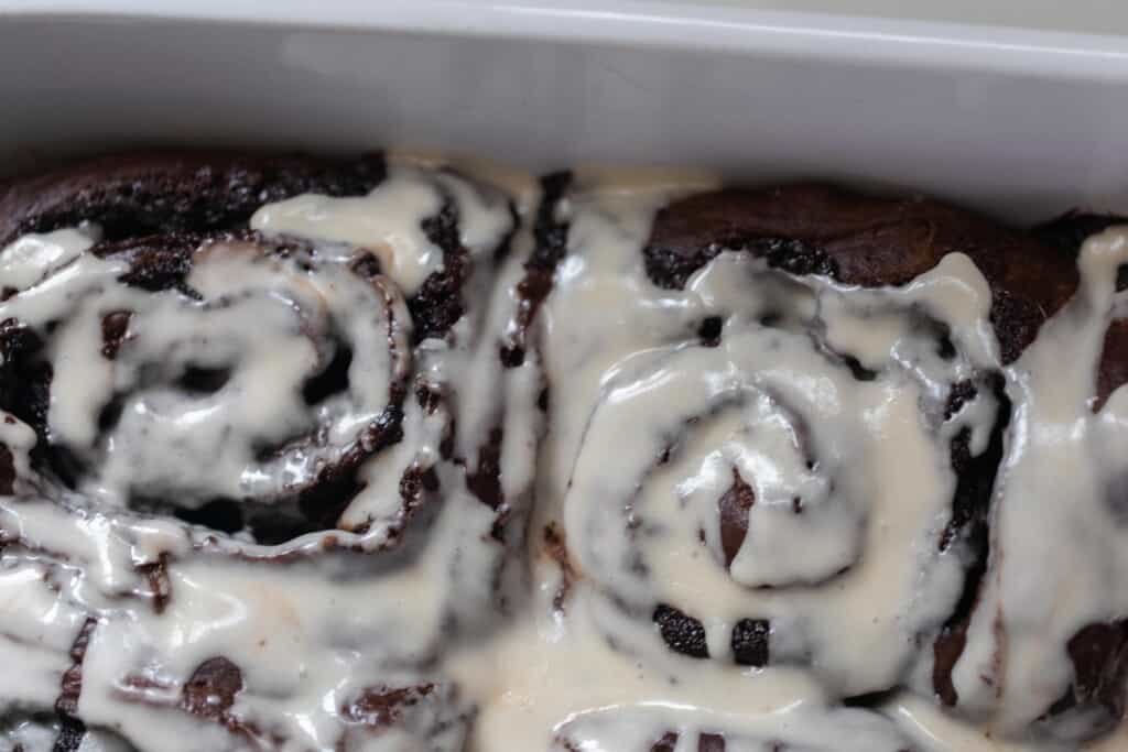 close up of photo of a sourdough chocolate roll topped with vanilla icing