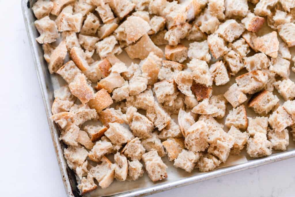 sourdough bread cut up into cubes on a baking sheet