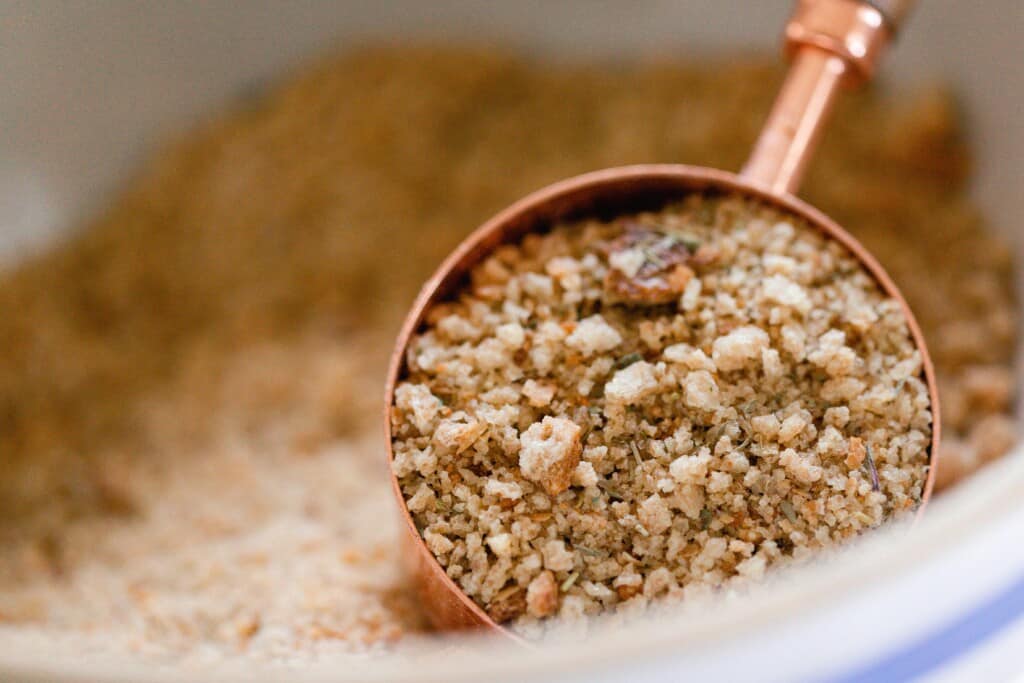 copped cup full of bread crumbs  coming out of a bowl of bread crumbs