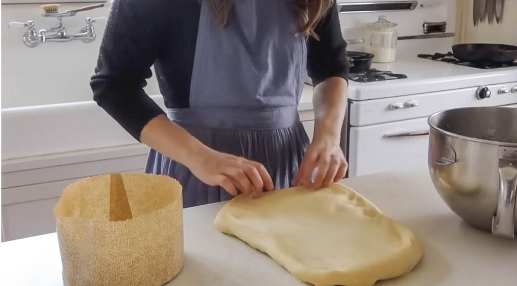 spreading dough onto white quartz countertop