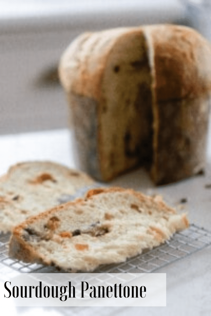 A sourdough panettone loaf with two slices cut out, laying on a cooling rack