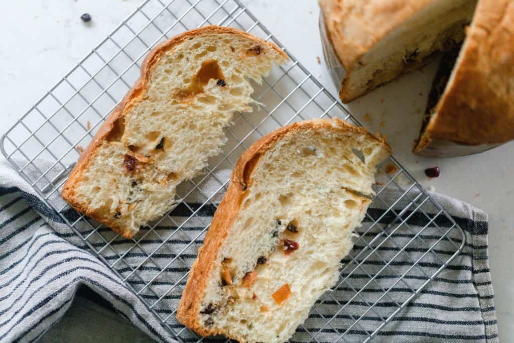 two slices of sourdough panettone on a cooling wrack