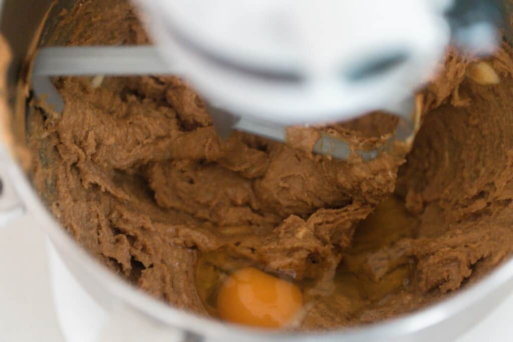 egg being added to creamed butter and sugar