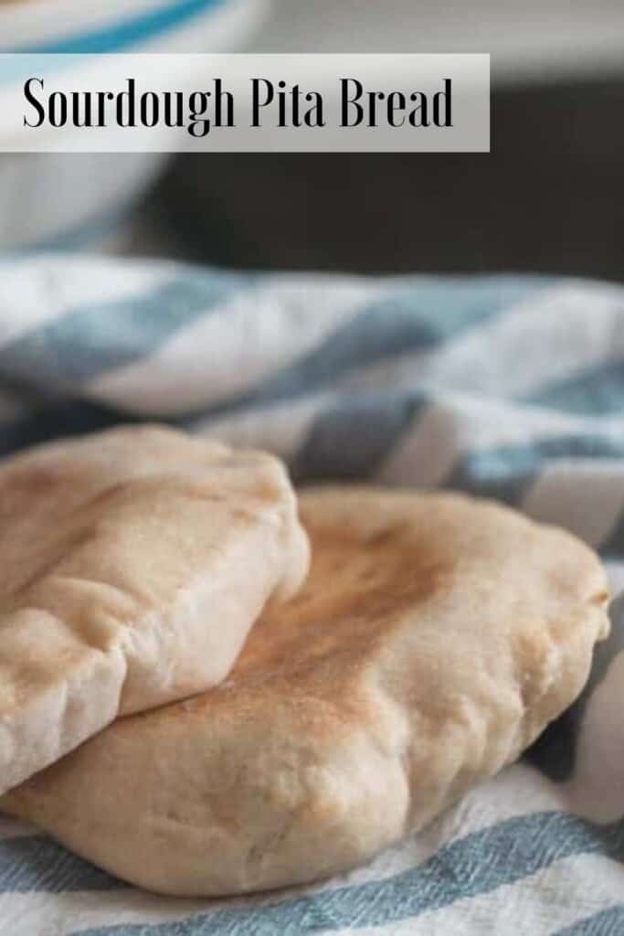 two sourdough pita bread on a white and blue stripped towel