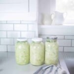 Three jars filled with fermenting cabbage.