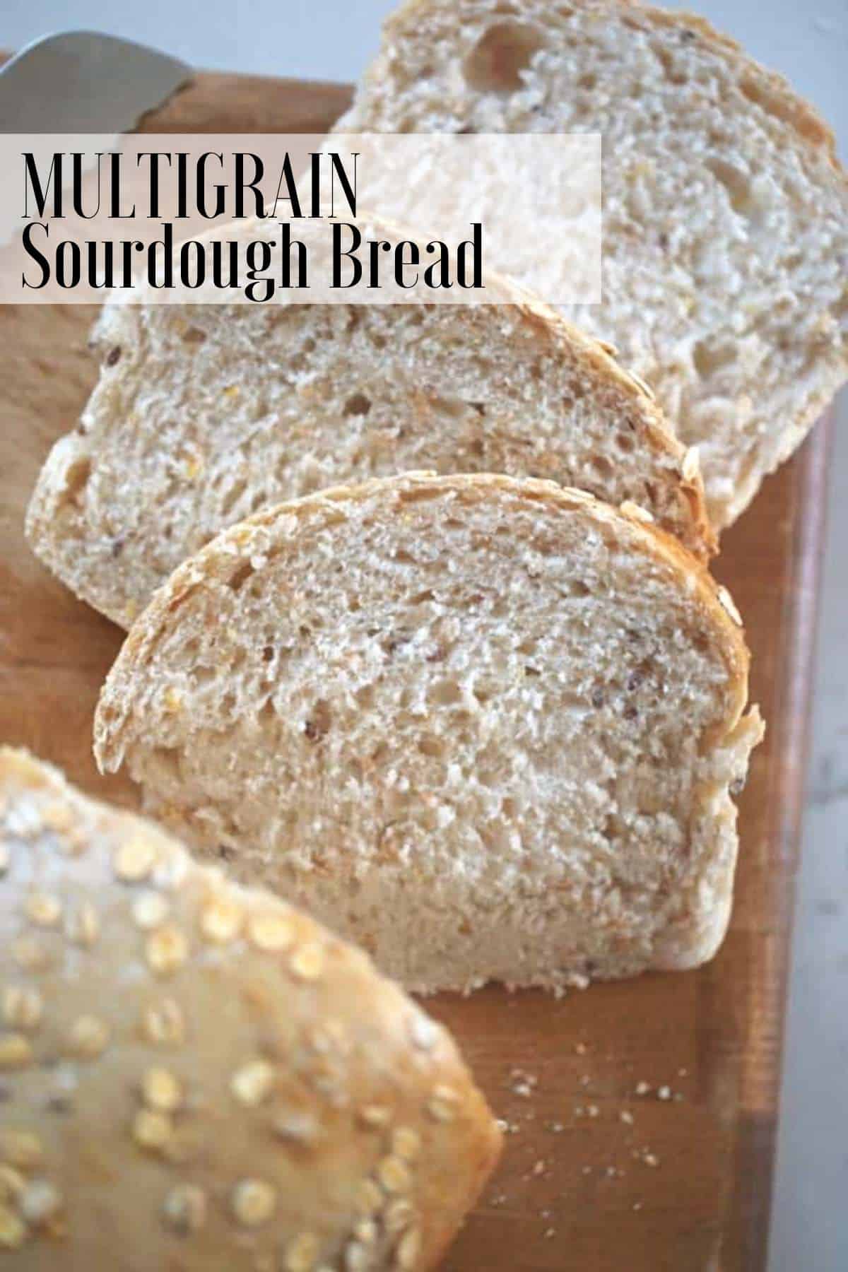 overhead photo of a loaf of multigrain sourdough bread sliced on a cutting board