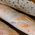 three loaves of sourdough baguettes with one cut open