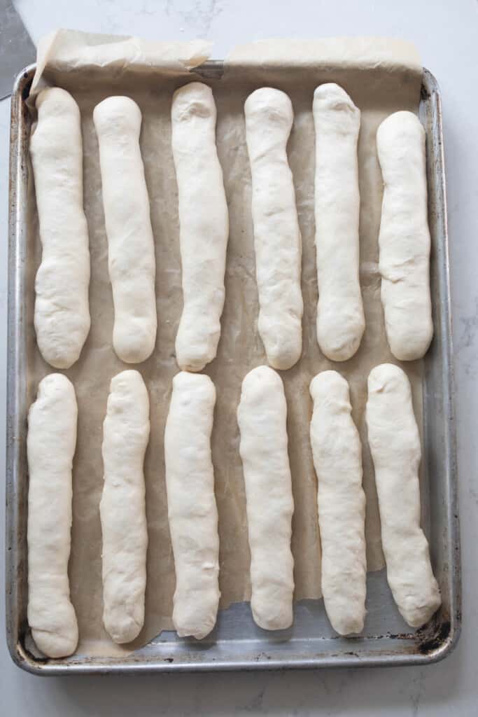 shaped sourdough breadsticks before baking on a parchment paper lined baking sheet