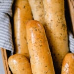 overhead photo of sourdough bread sticks in a towel lined basket