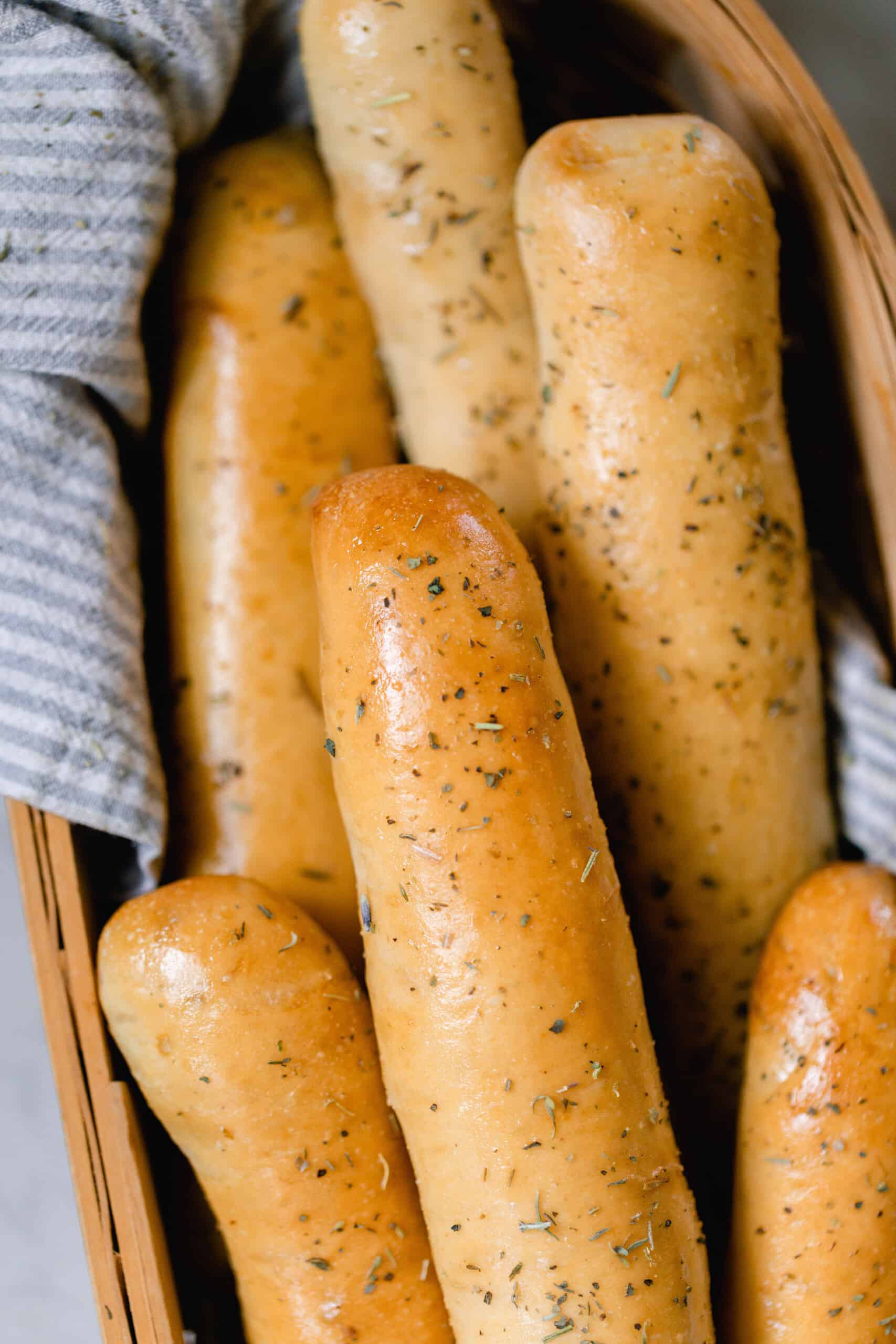 overhead photo of sourdough bread sticks in a towel lined basket